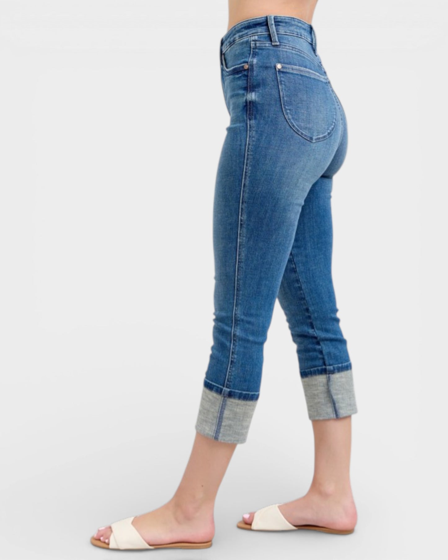 Blue jeans with rolled-up cuffs on a white background