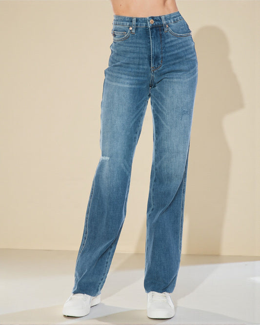 Blue jeans worn by a person on a beige background
