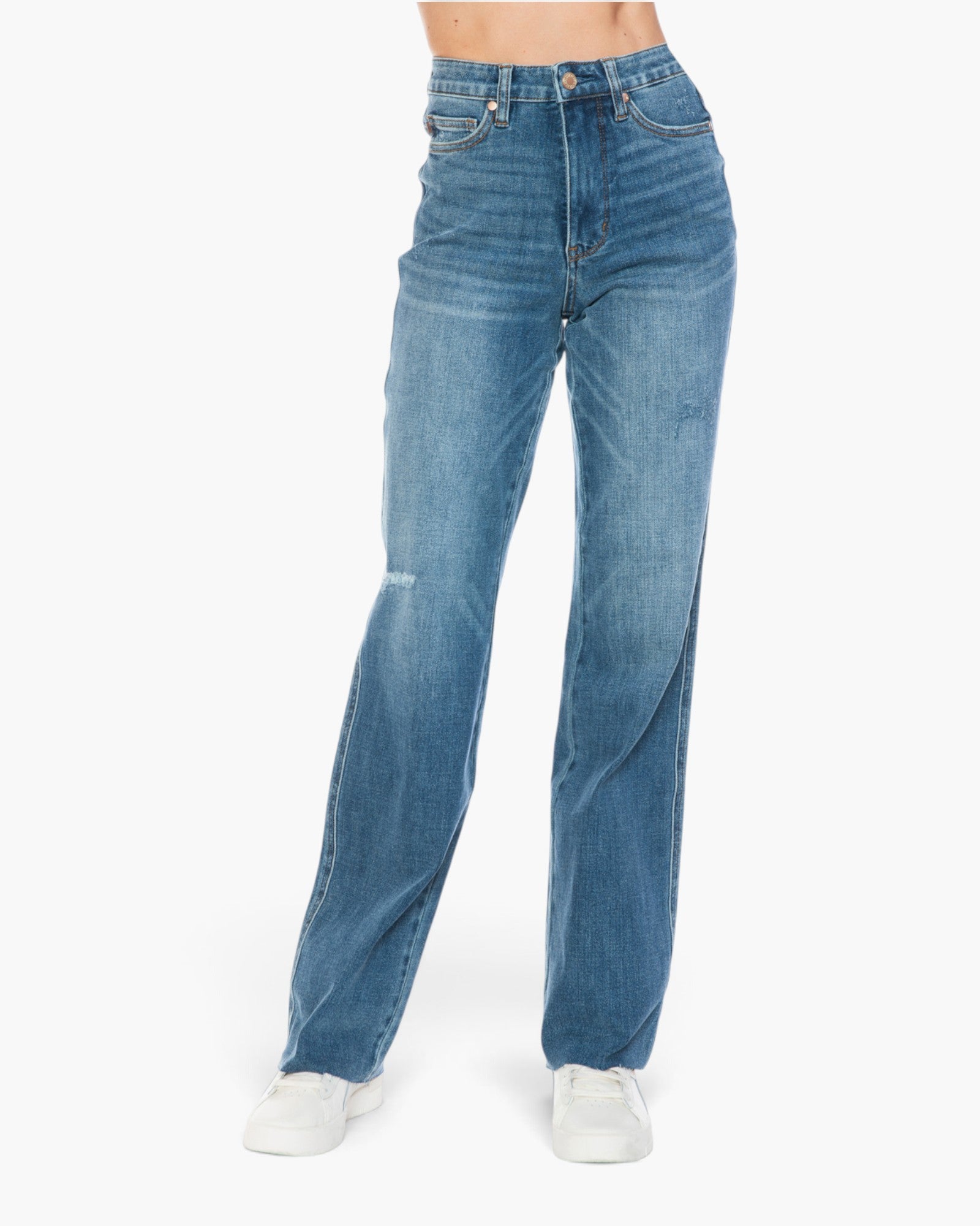 A person wearing medium-wash blue denim jeans with a straight-leg fit and white sneakers, shown from the waist down against a plain white studio background.
