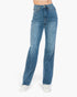 A person wearing medium-wash blue denim jeans with a straight-leg fit and white sneakers, shown from the waist down against a plain white studio background.