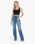 A woman modeling a pair of high-waisted, wide-leg blue jeans with a black crop tank top and white sneakers, standing against a plain white studio background.