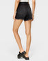 Person wearing black denim shorts on a white background