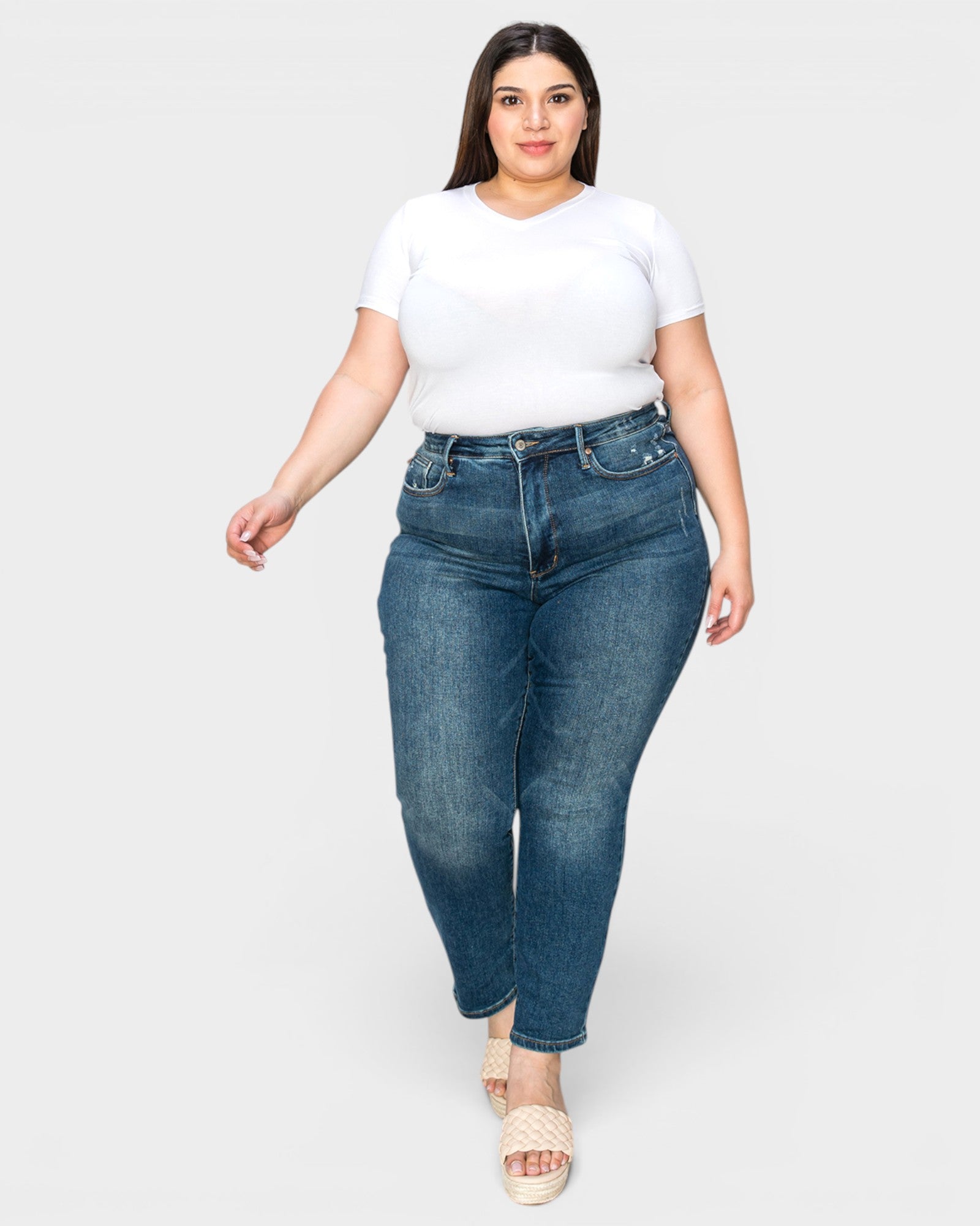 Woman wearing a white t-shirt and blue jeans on a white background