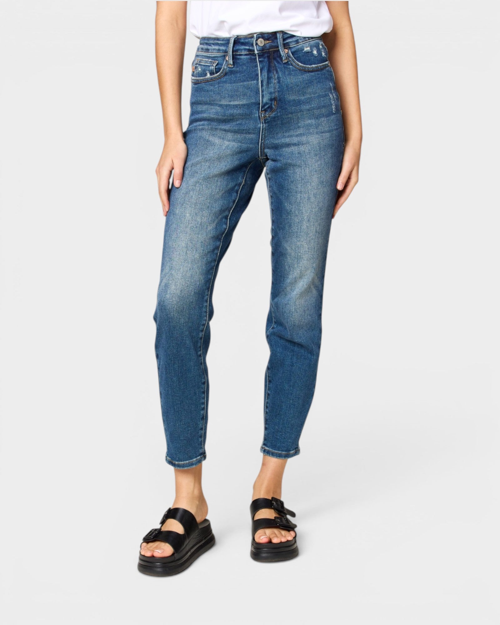 Person wearing blue jeans on a white background