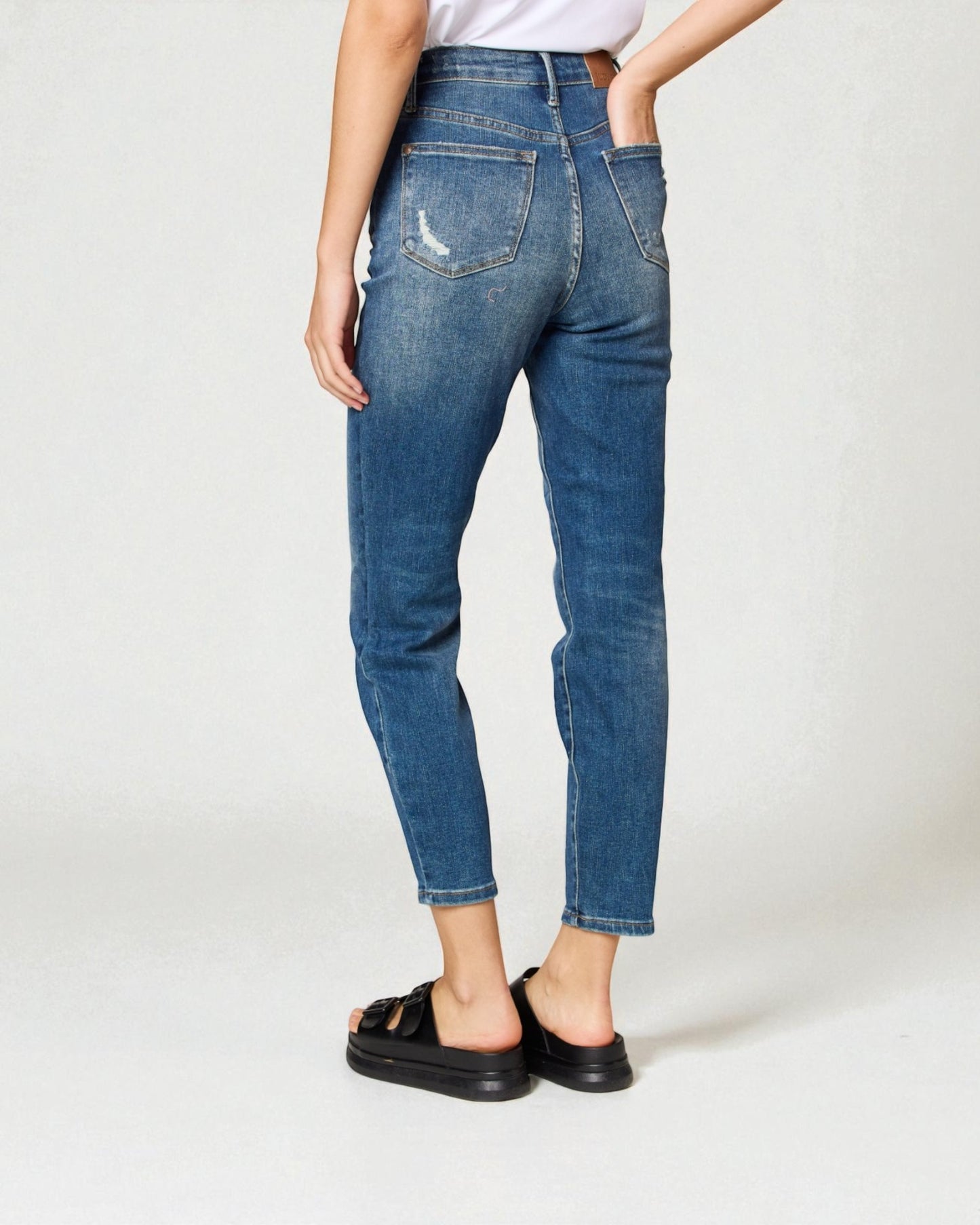 Person wearing blue jeans on a white background