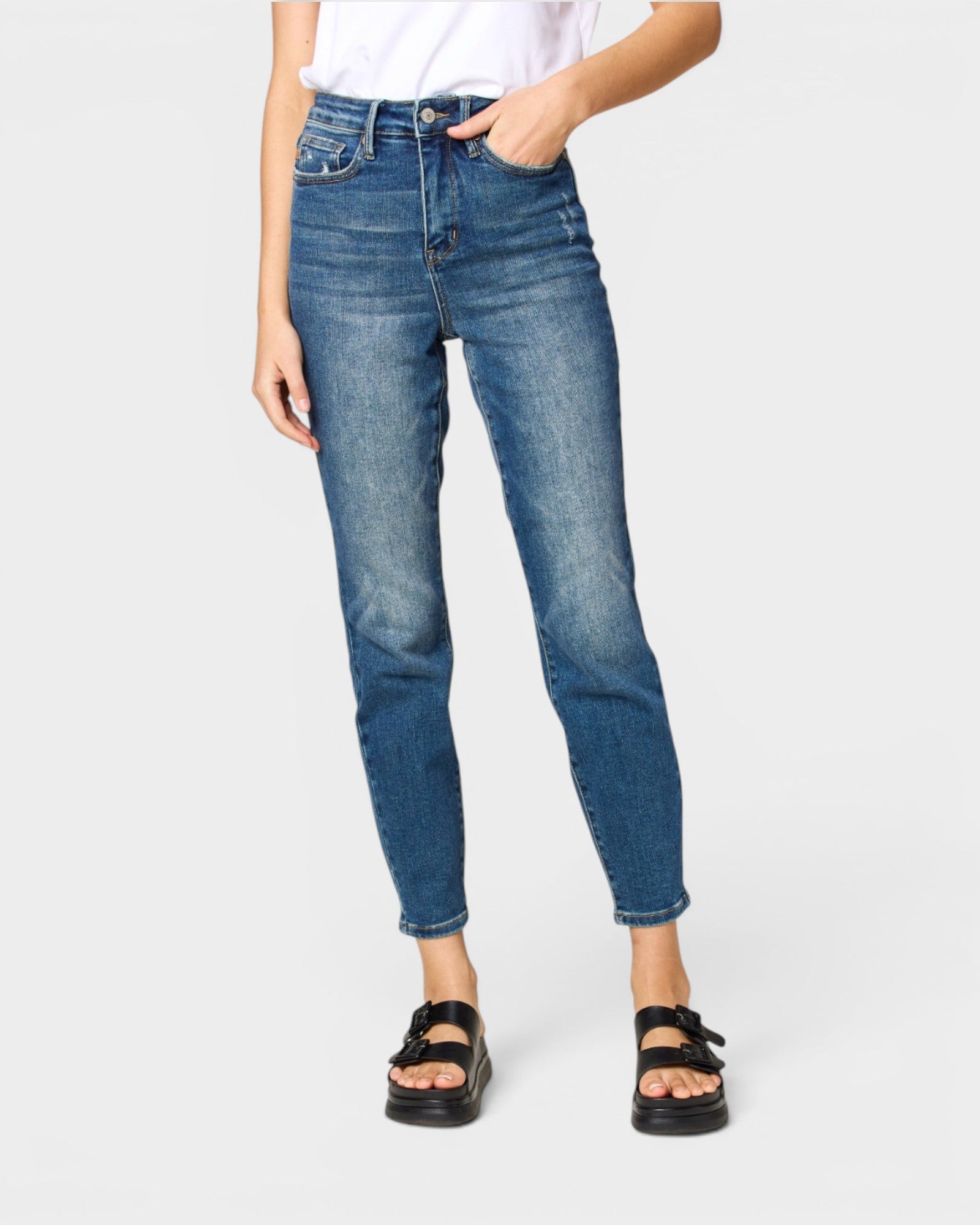 Person wearing blue jeans on a white background
