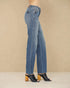 Blue jeans worn by a person on a beige background