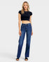 Woman wearing blue jeans and a black top on a white background