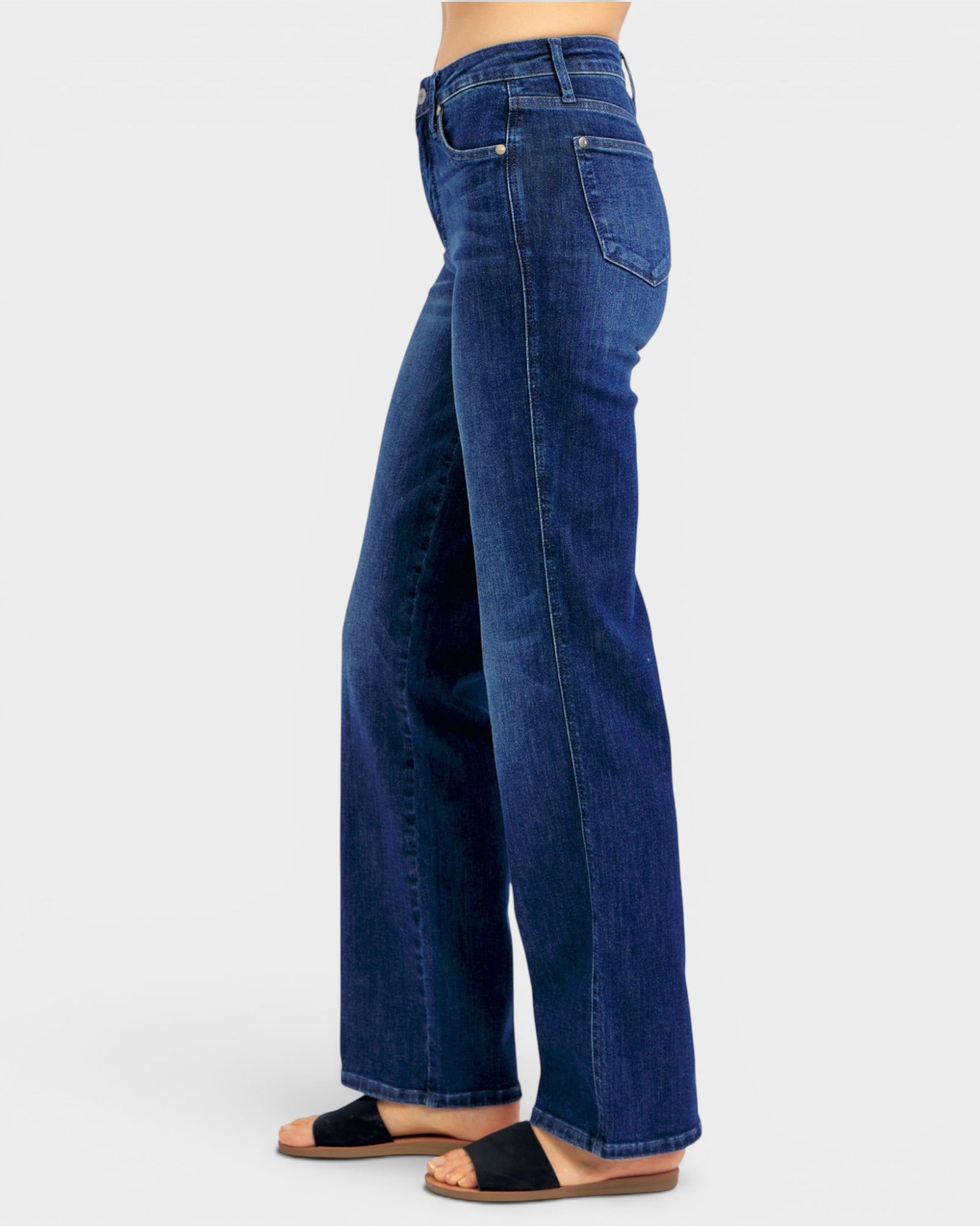 Person wearing blue jeans on a light gray background