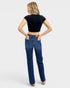 Woman wearing blue jeans and a black crop top on a white background