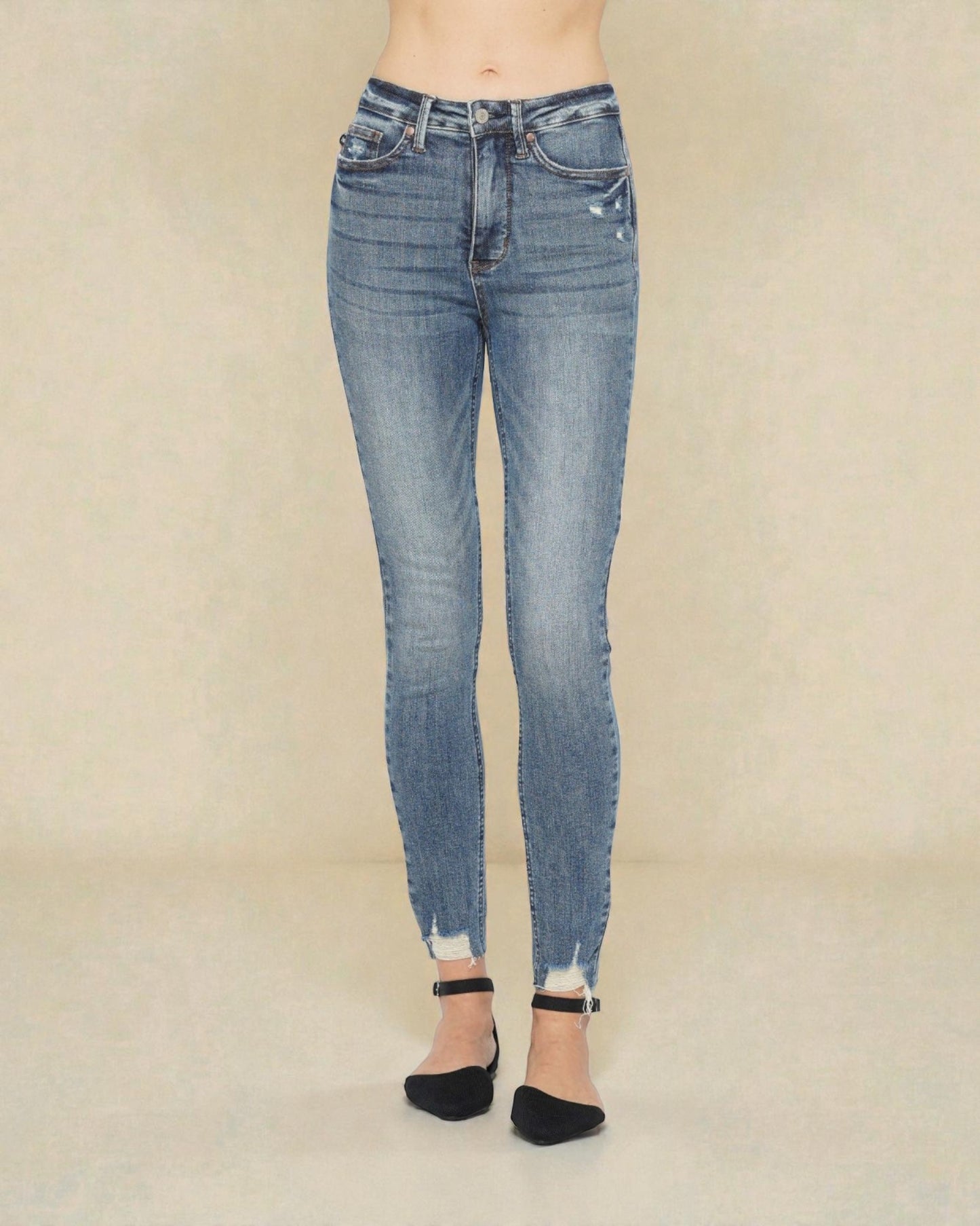 Blue jeans worn by a person on a beige background