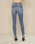 Blue jeans worn by a person on a beige background
