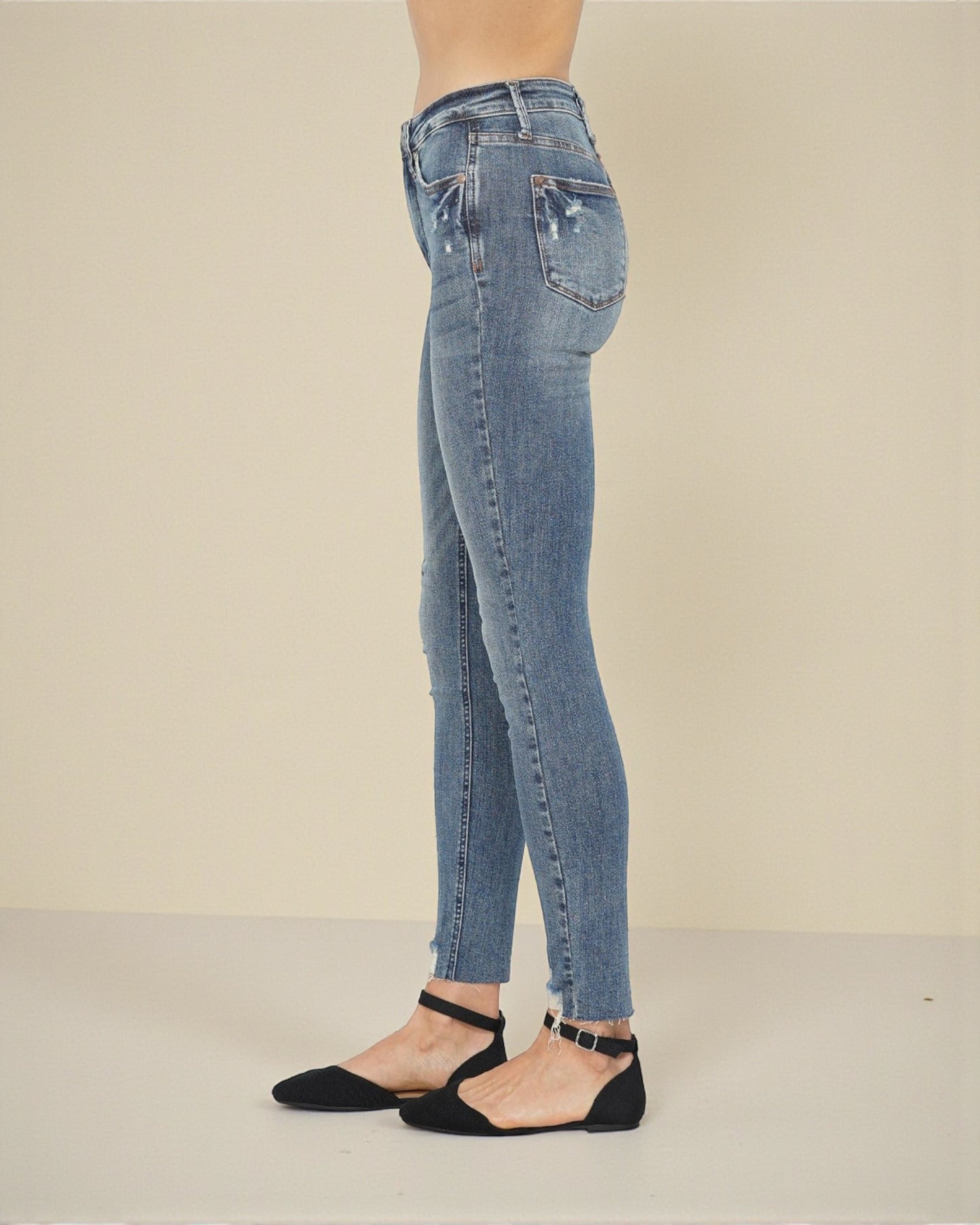 Person wearing light blue jeans on a plain background