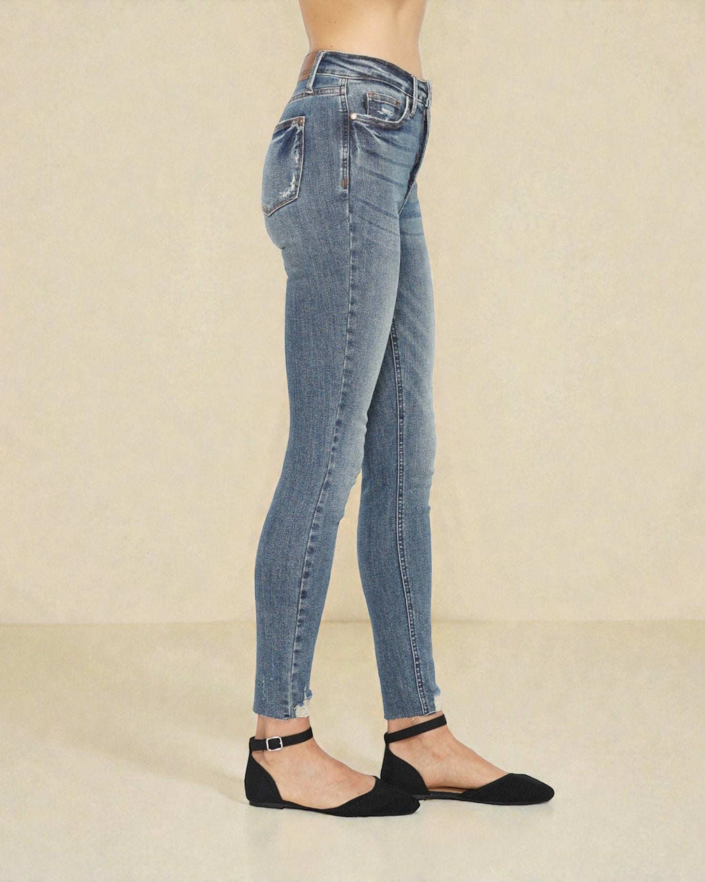 Light blue jeans worn by a person on a beige background