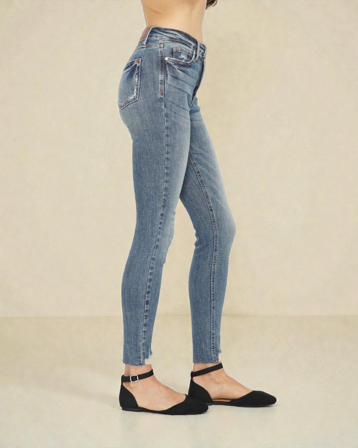 Light blue jeans worn by a person on a beige background