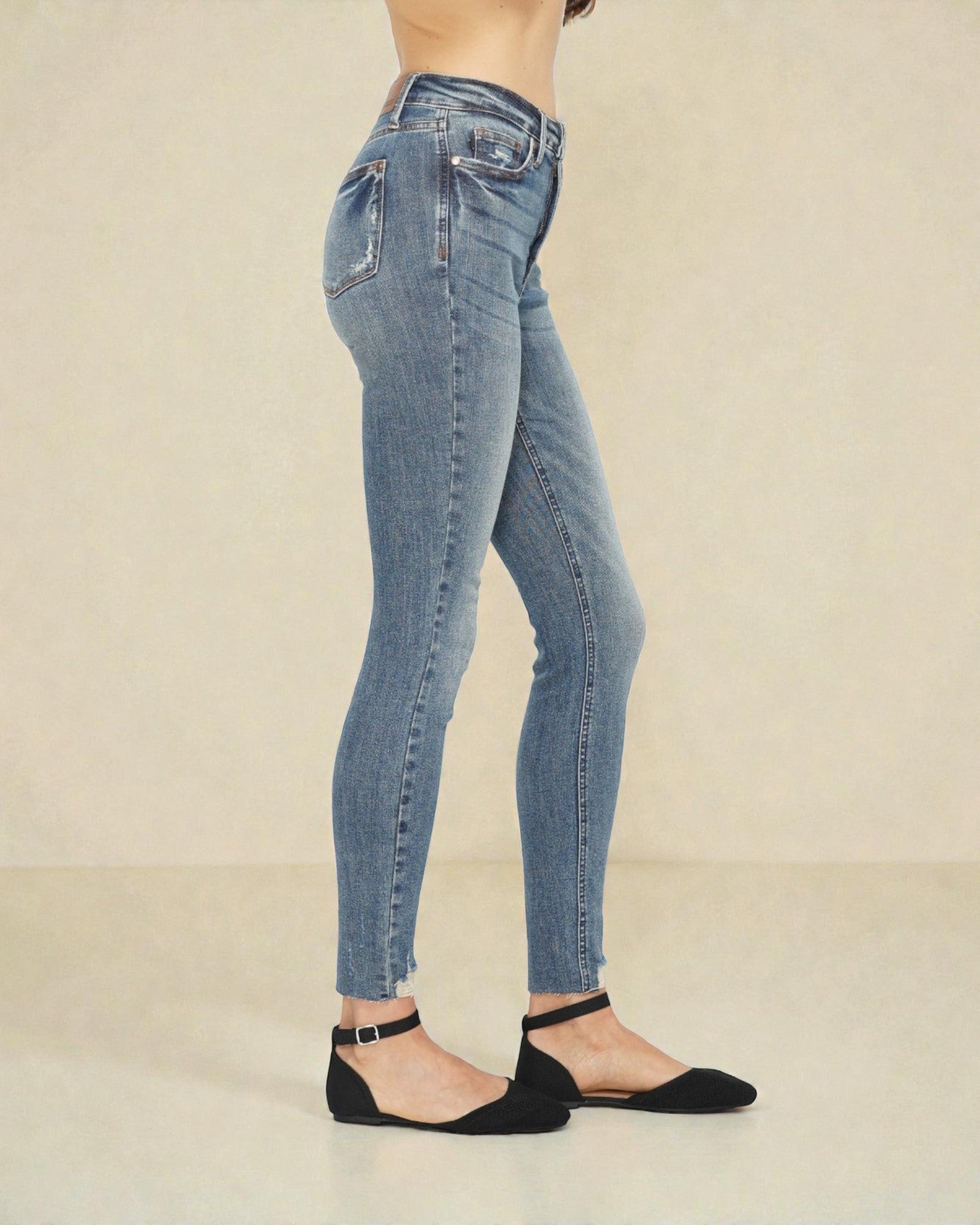 Light blue jeans worn by a person on a beige background