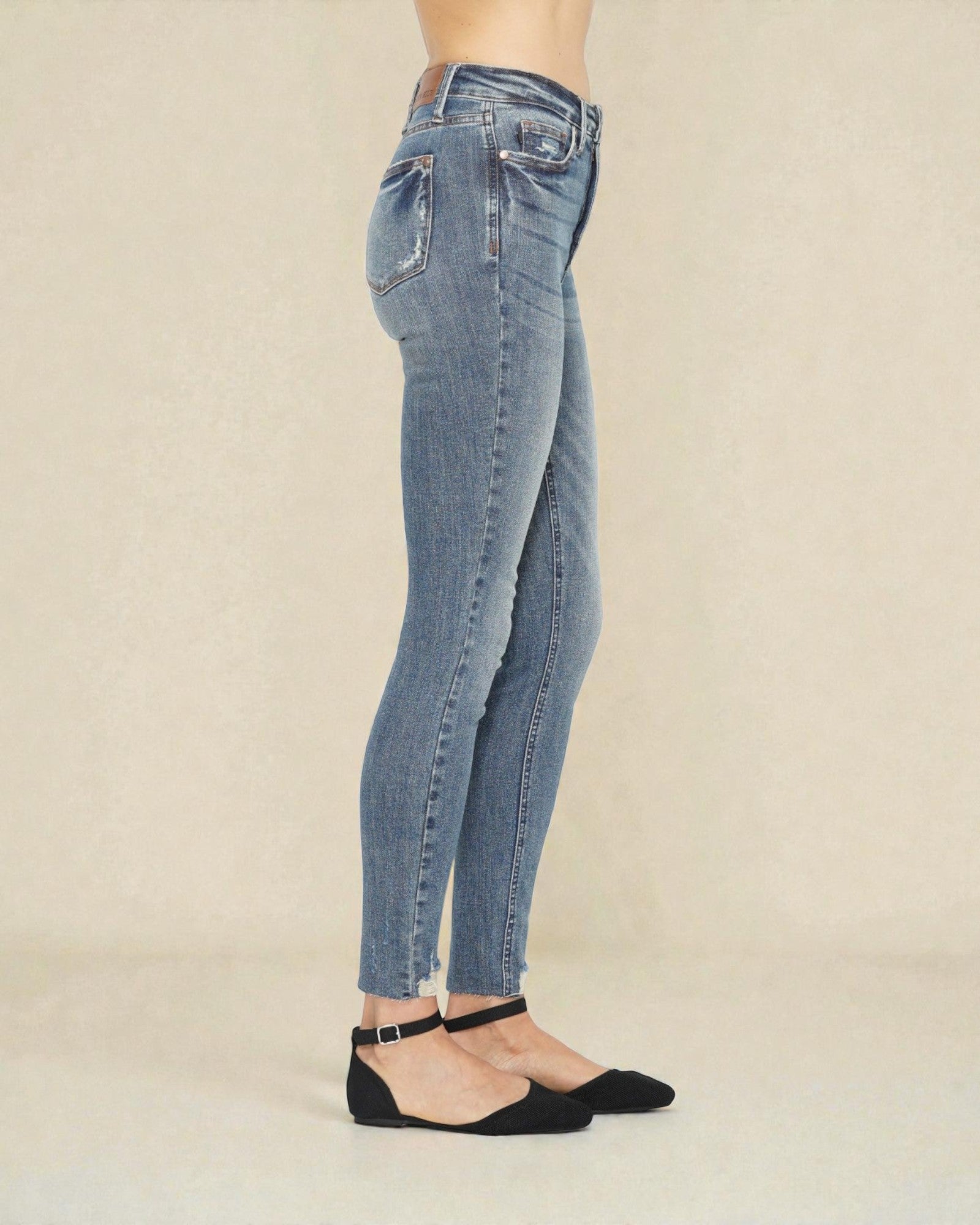 Light blue jeans worn by a person on a beige background