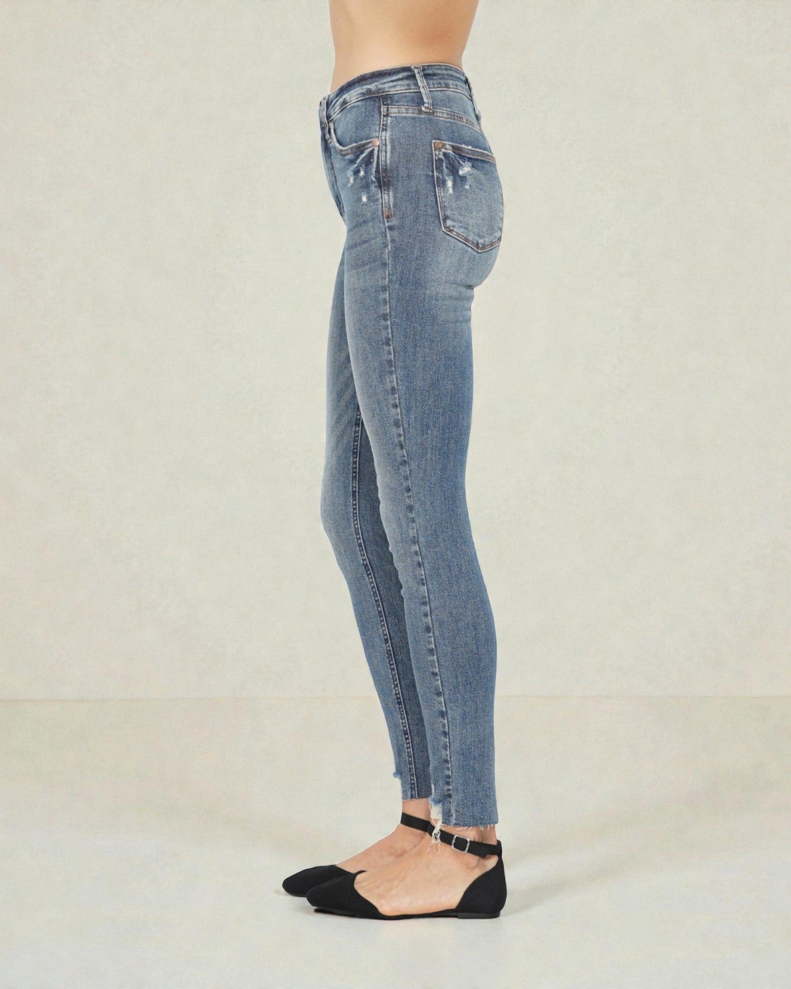 Blue jeans worn by a person on a plain background