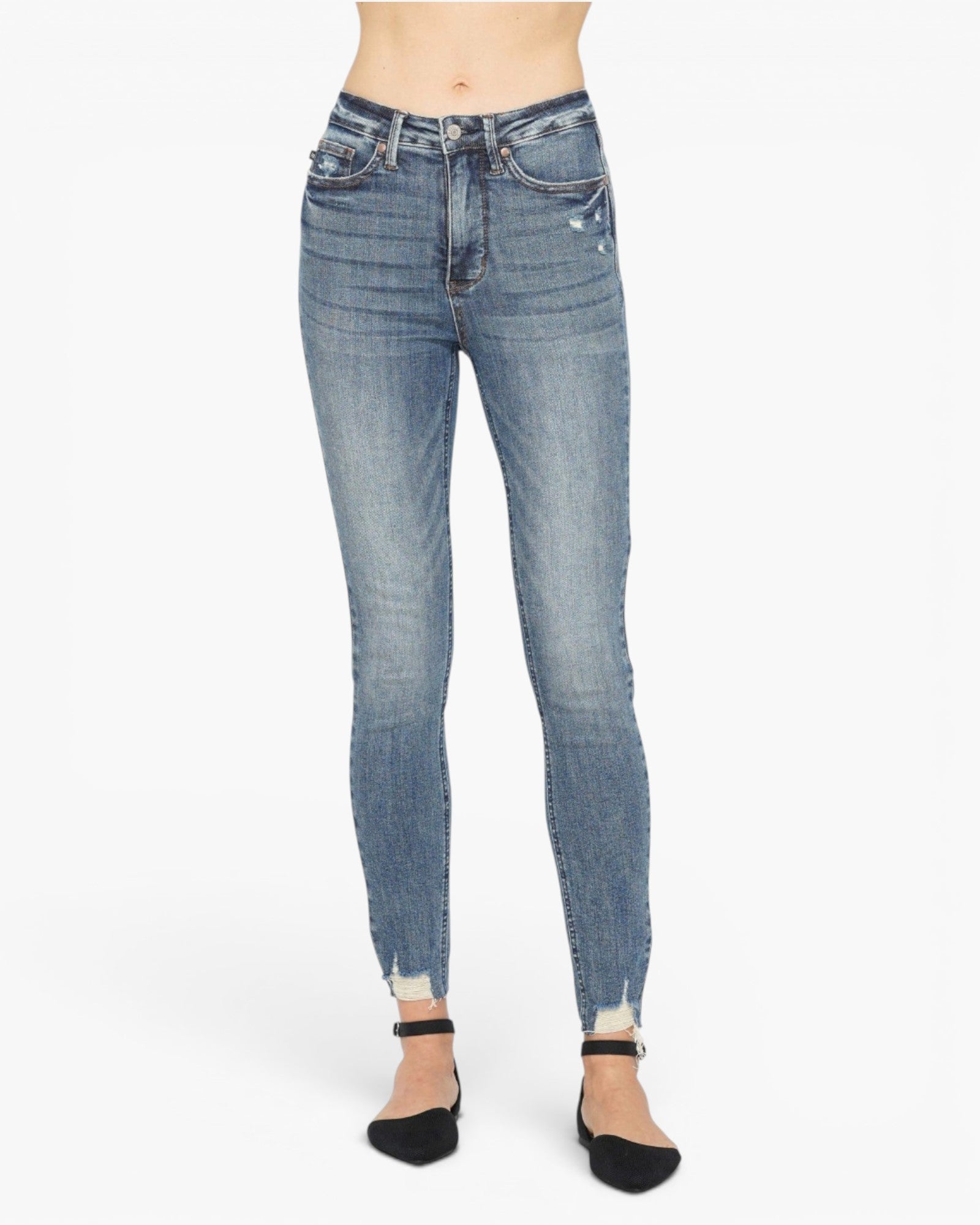 A person wearing light blue skinny jeans with a faded wash and rolled hems, paired with black pointed flats, shown against a plain white studio background.