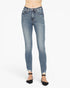 A person wearing light blue skinny jeans with a faded wash and rolled hems, paired with black pointed flats, shown against a plain white studio background.