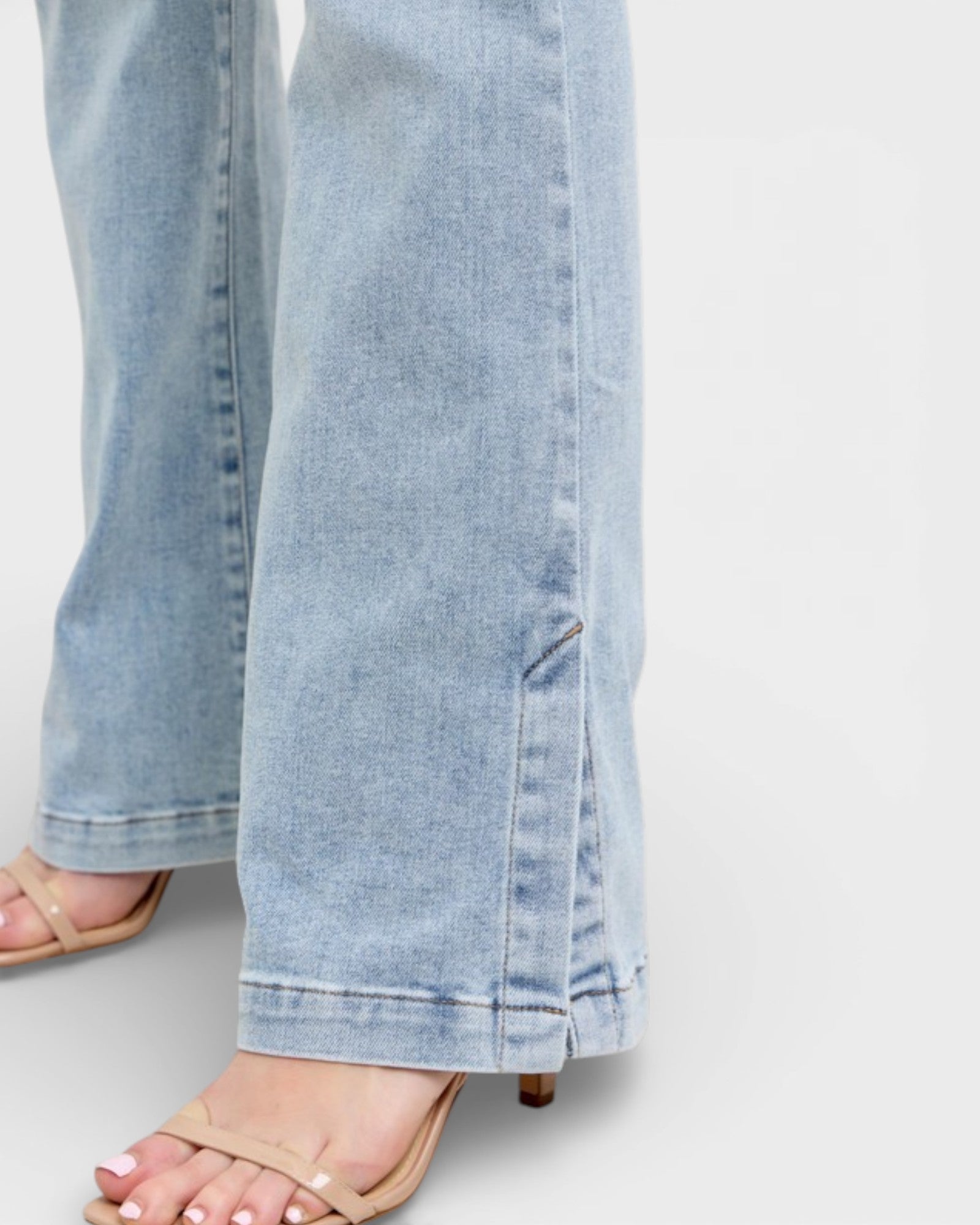 Light blue jeans worn by a person on a white background