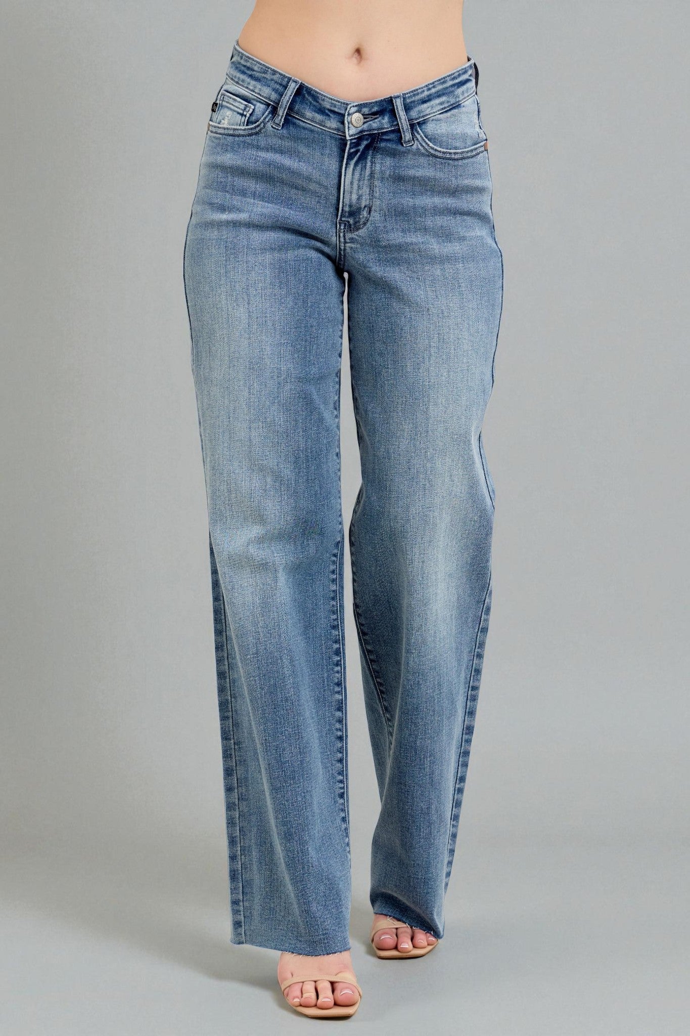 Light blue jeans worn by a person on a gray background