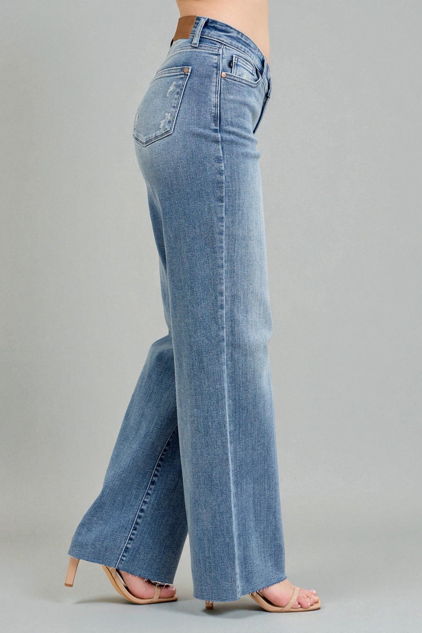 Blue jeans worn by a person on a gray background