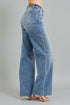 Blue jeans worn by a person on a gray background