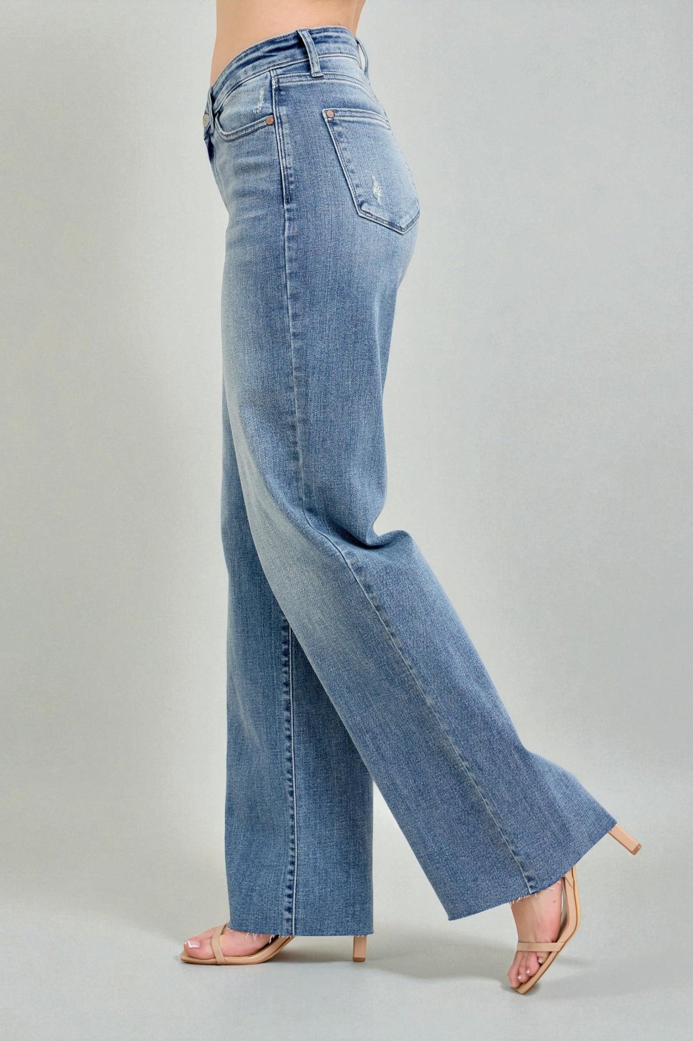 Light blue jeans worn by a person on a gray background