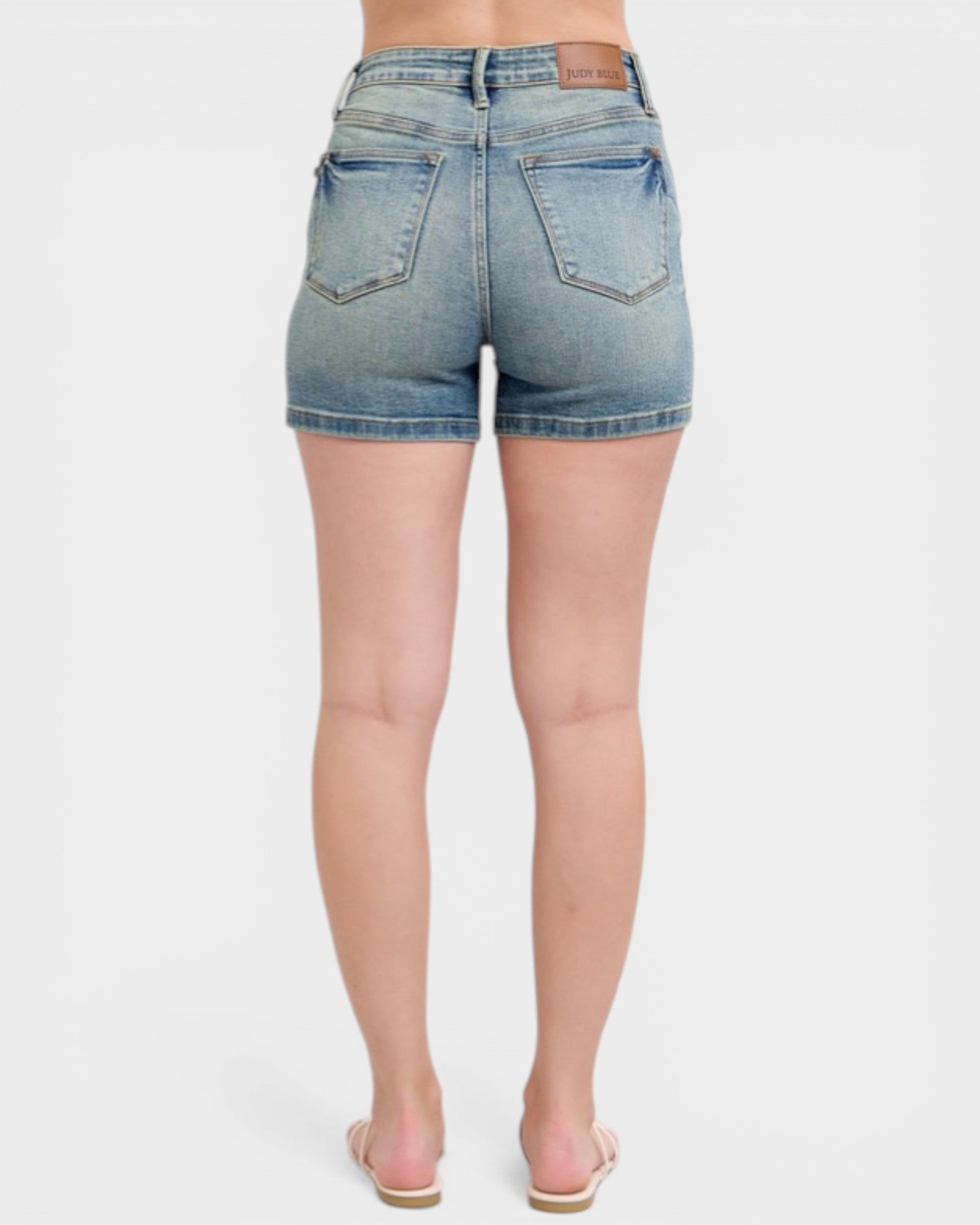 Denim shorts worn by a person on a white background