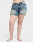 Denim shorts worn by a person on a white background