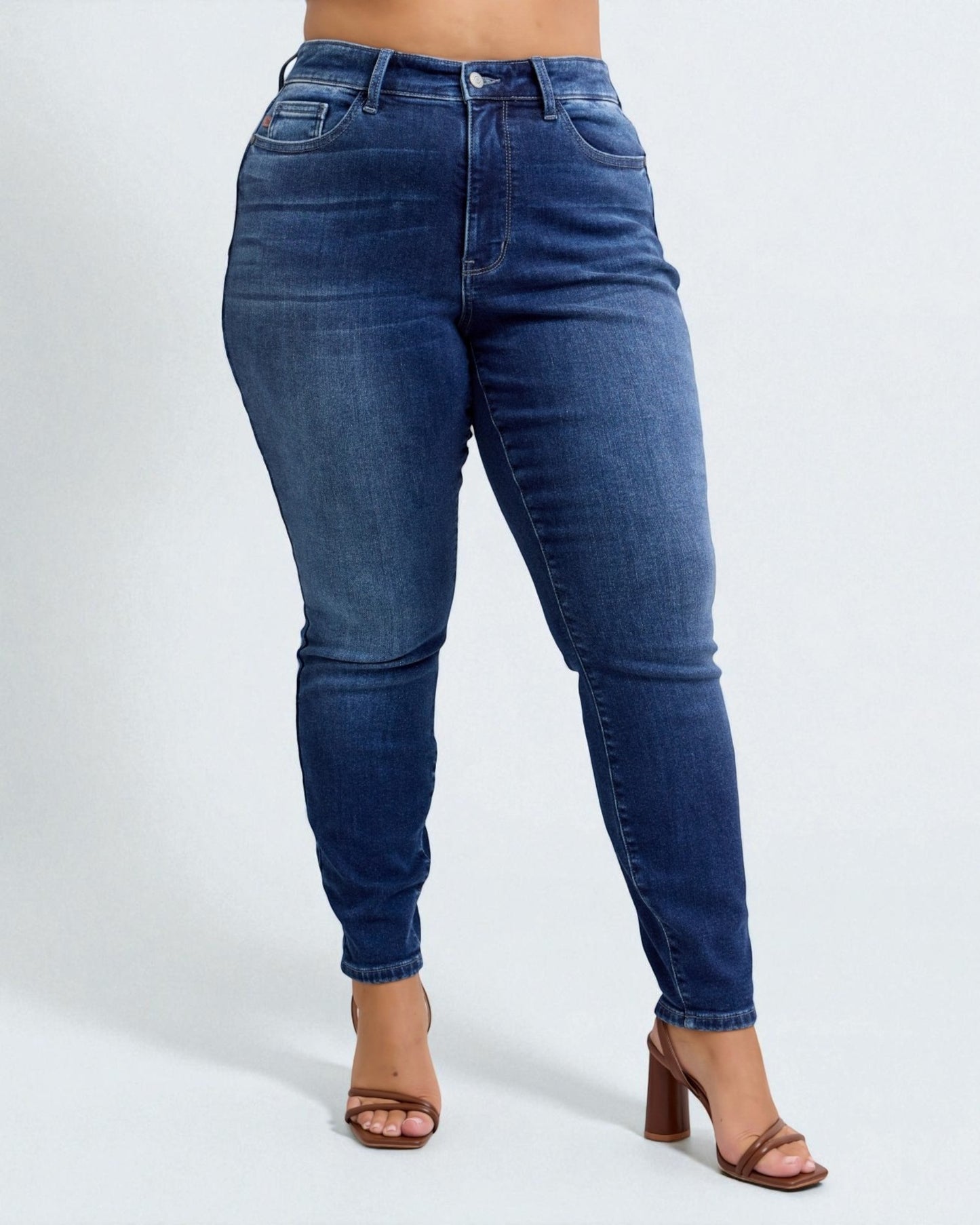 Blue jeans worn by a person on a white background