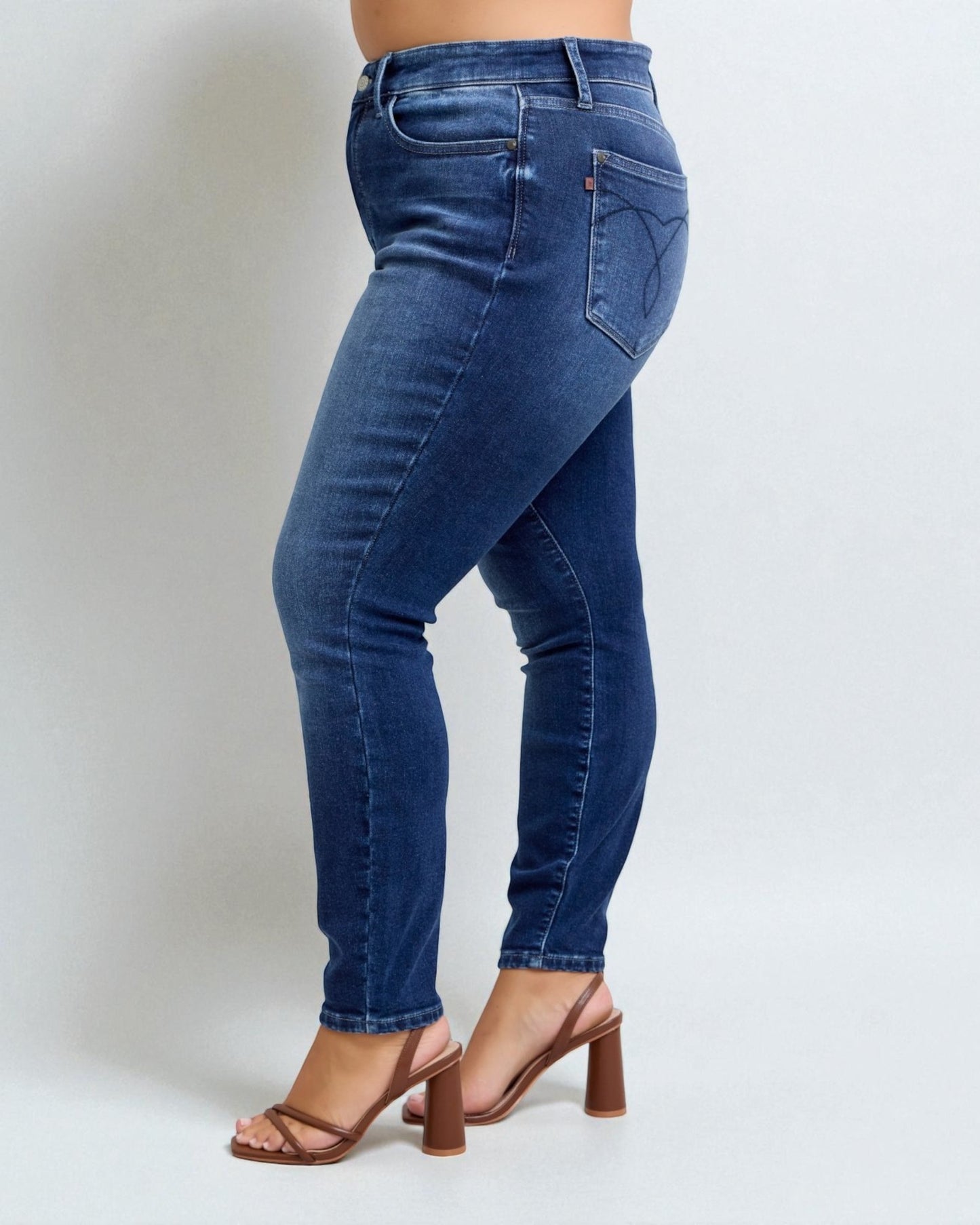 Blue jeans worn by a person on a white background