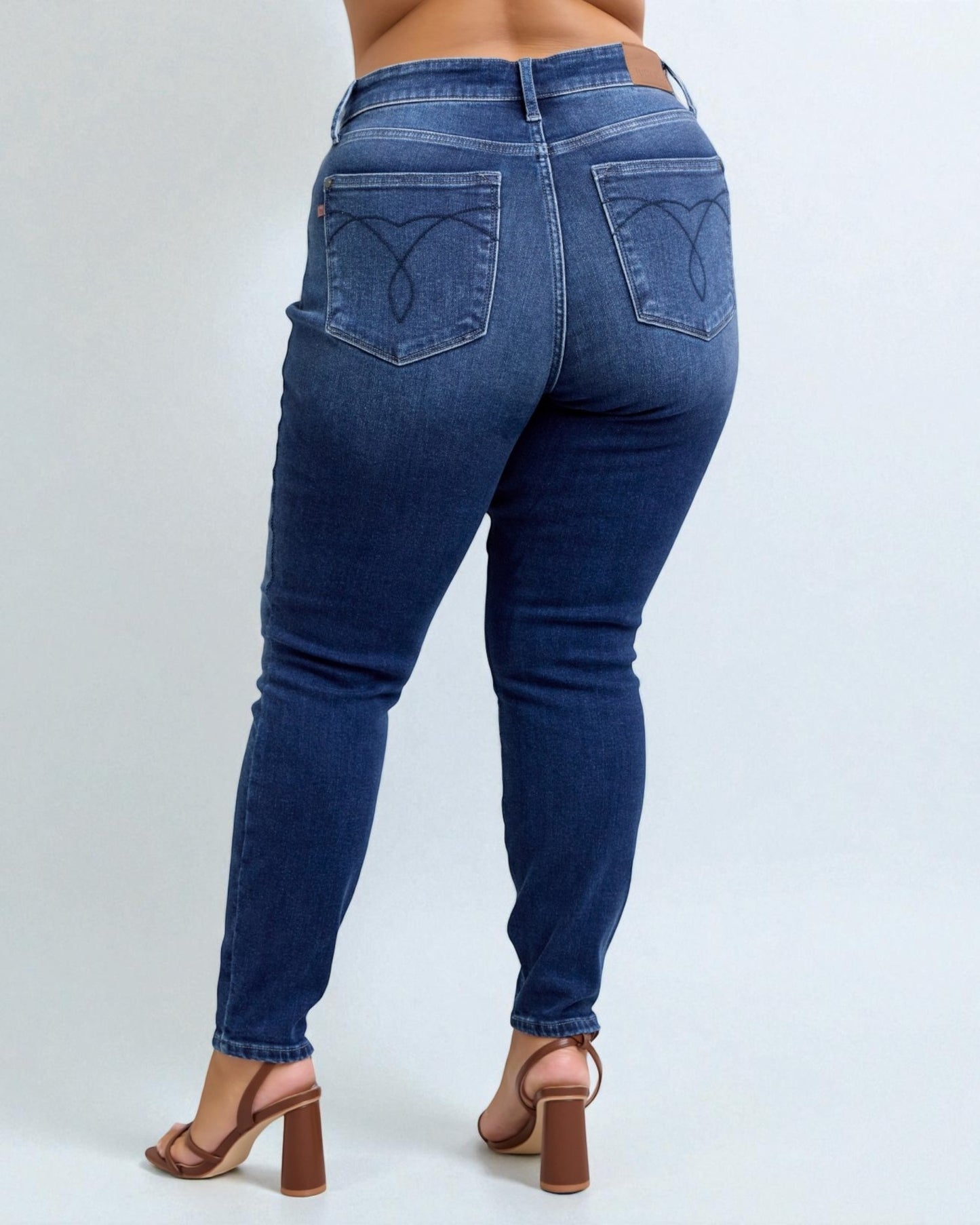 Blue jeans worn by a person on a white background