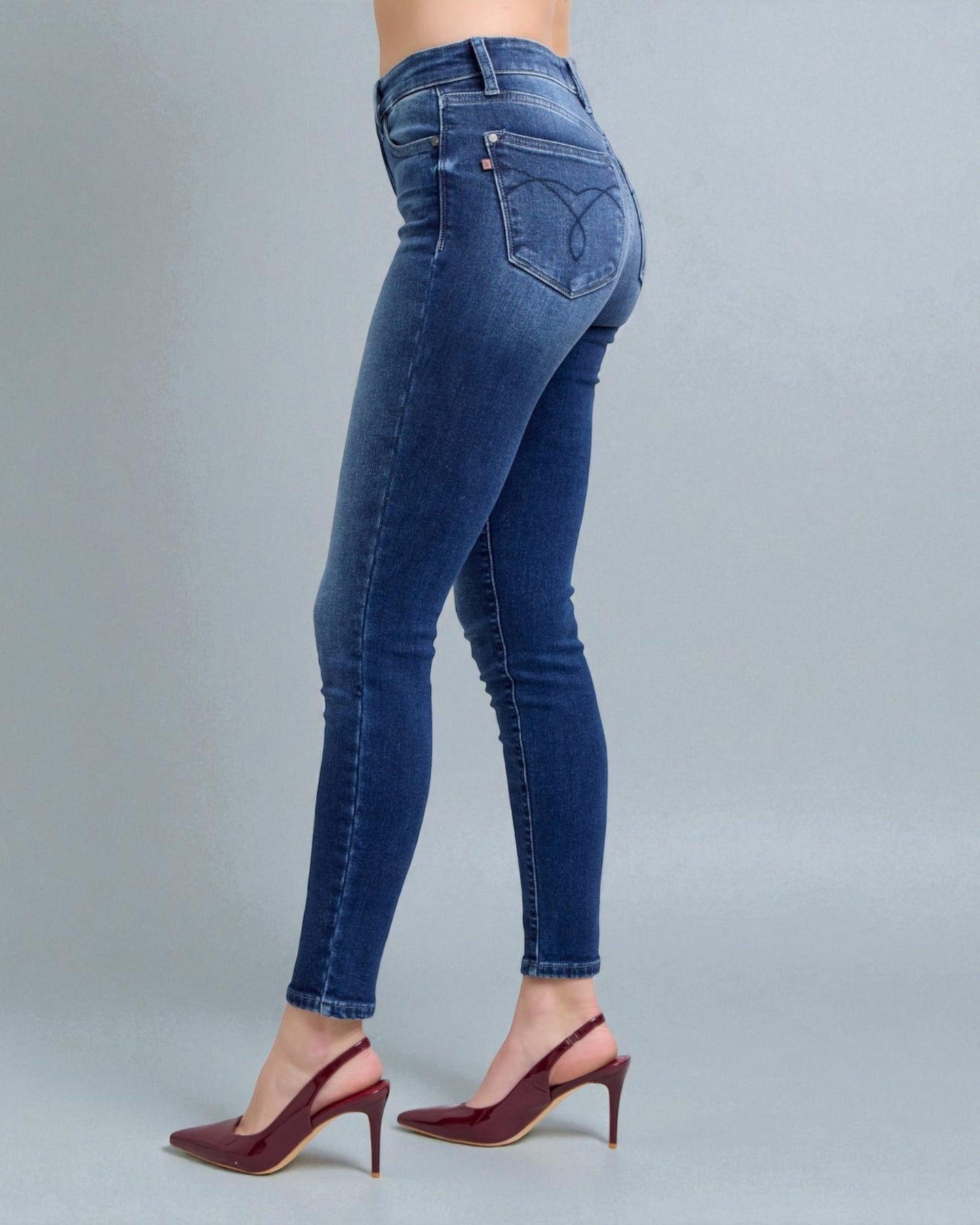 Blue jeans worn by a person on a gray background