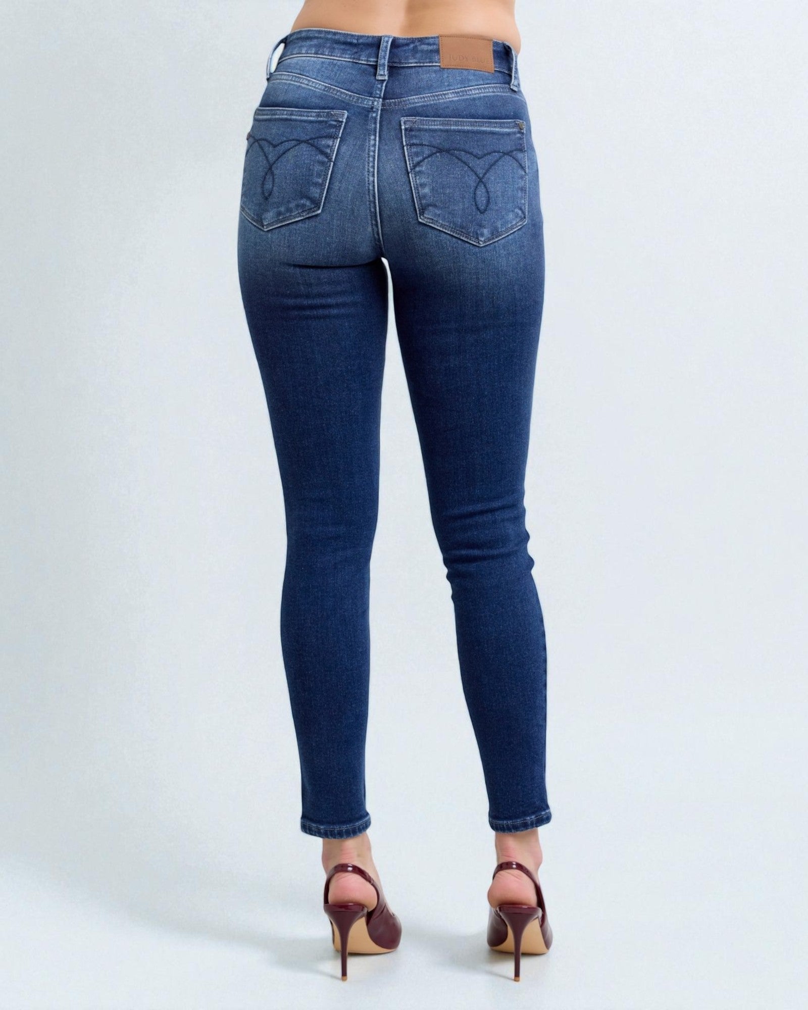 Blue jeans worn by a person on a white background