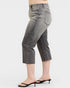 Person wearing gray cropped jeans on a white background