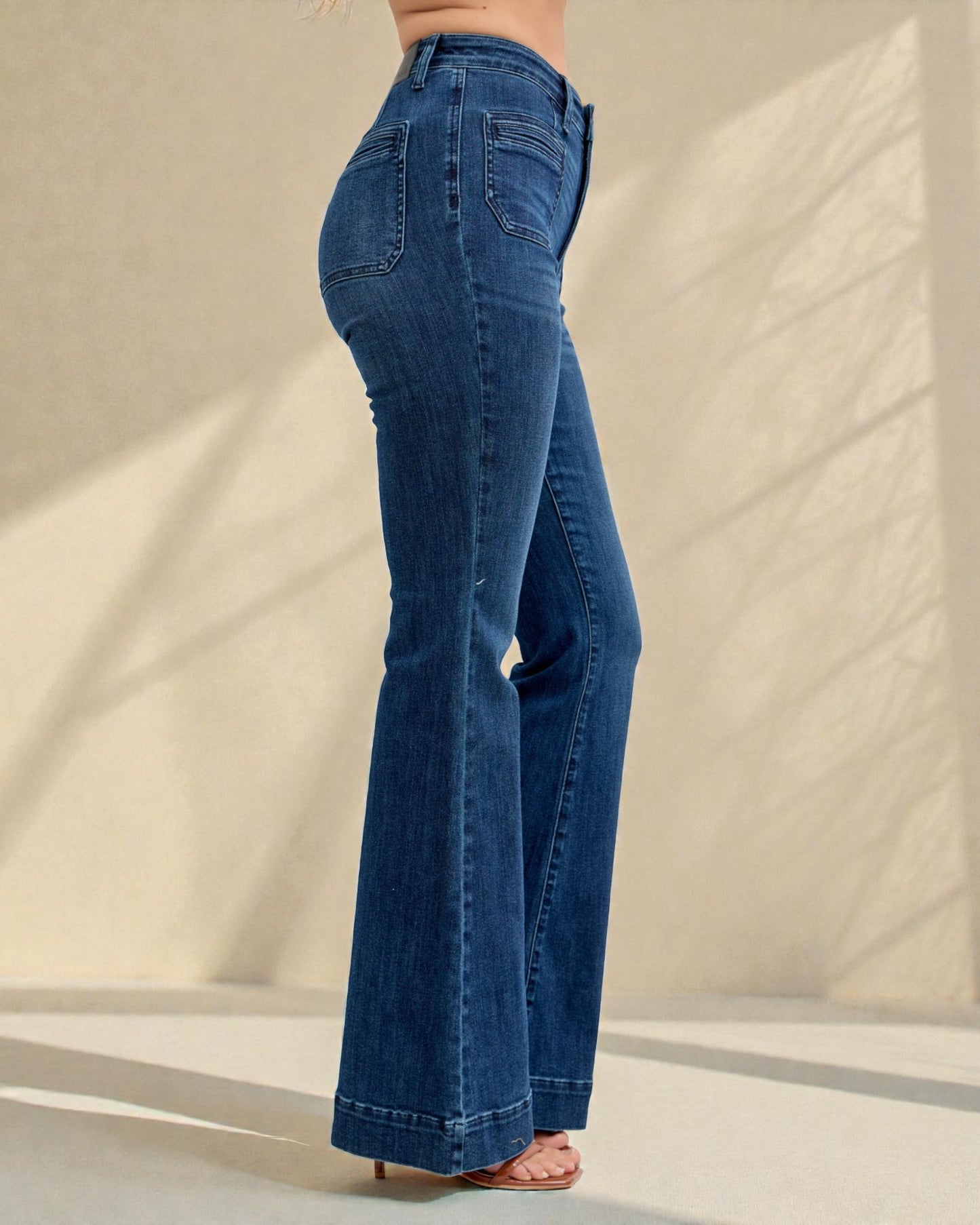 Blue jeans being worn against a neutral background