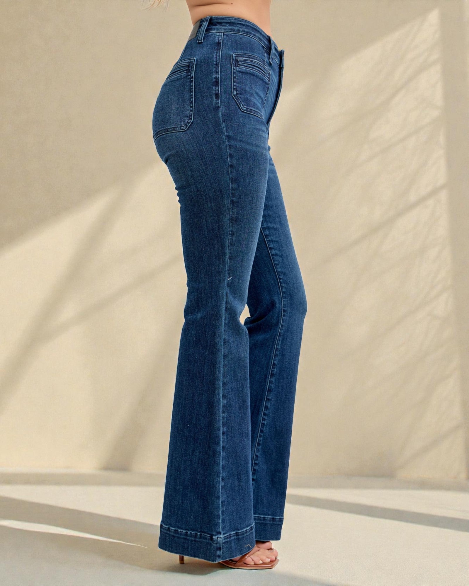 Blue jeans being worn against a neutral background