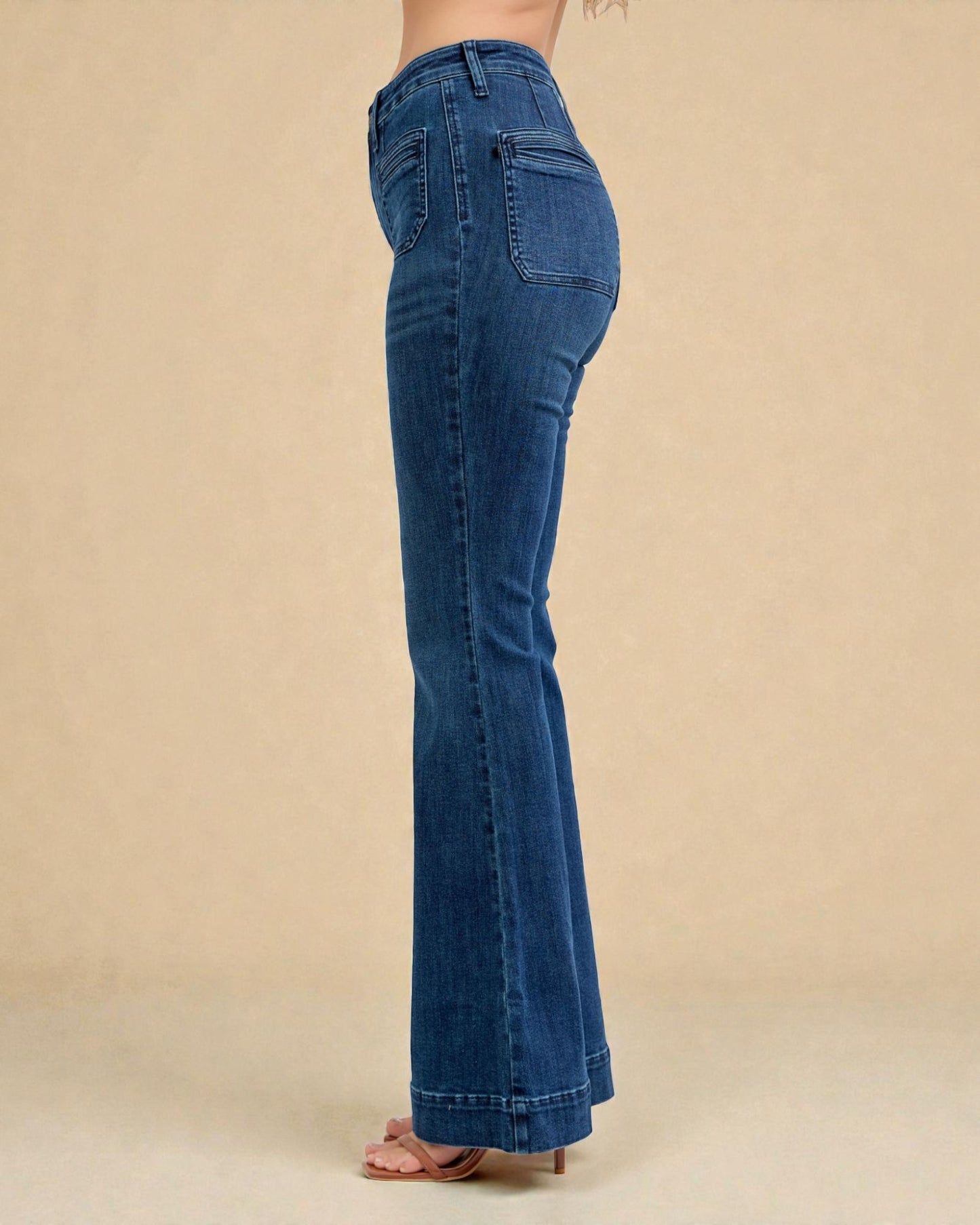 Blue jeans worn by a person on a beige background
