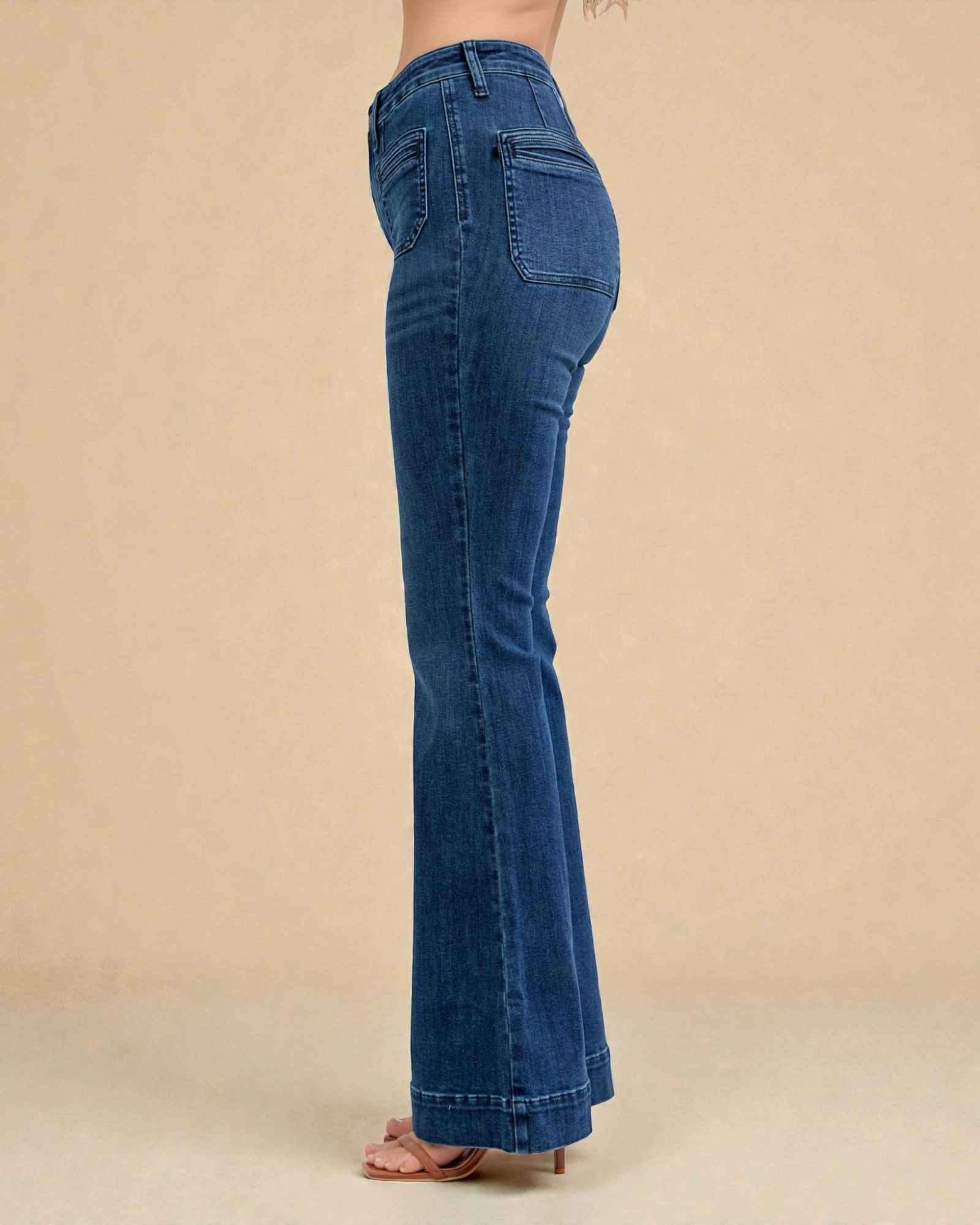 Blue jeans worn by a person on a beige background