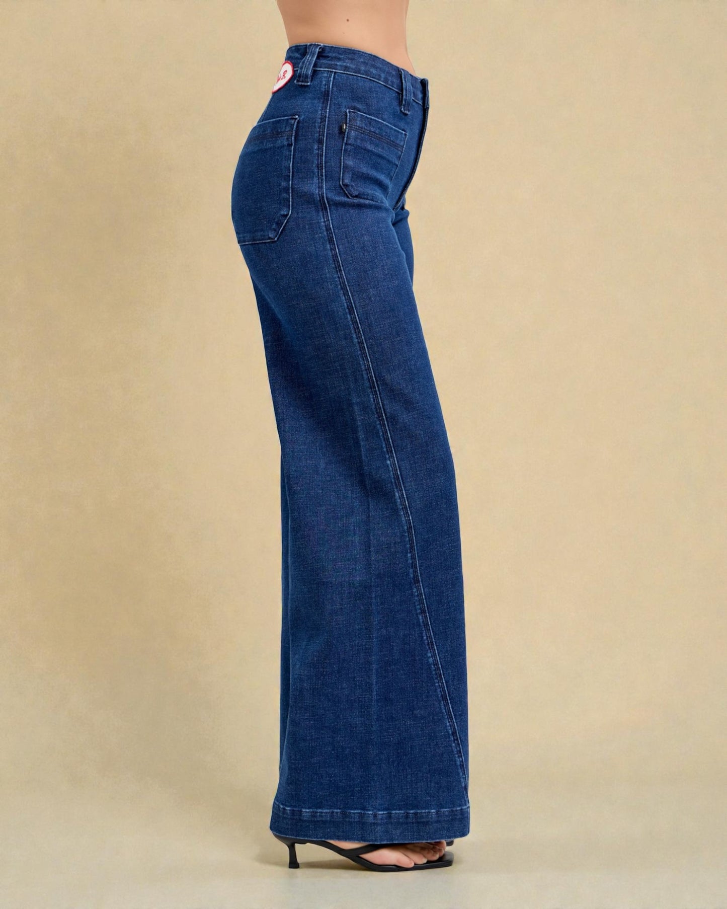 Blue jeans worn by a person on a beige background