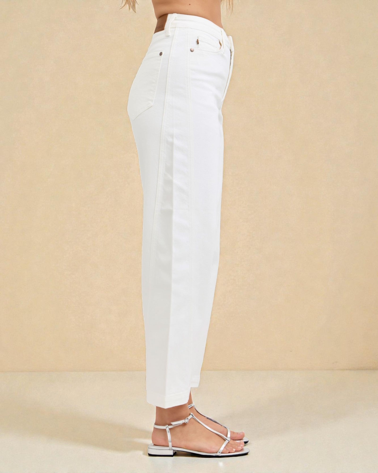 White jeans worn by a person on a beige background