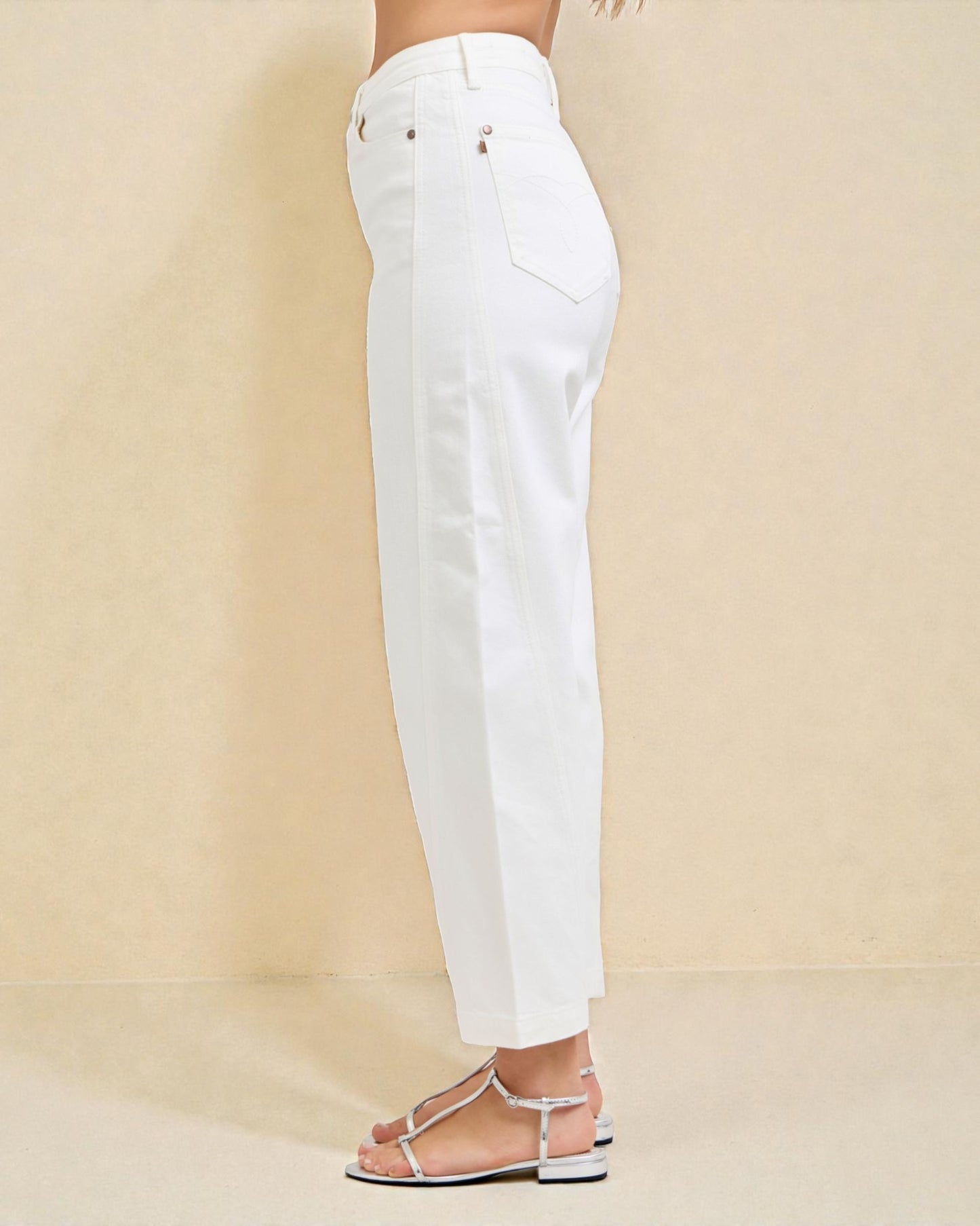 White jeans worn by a person on a beige background