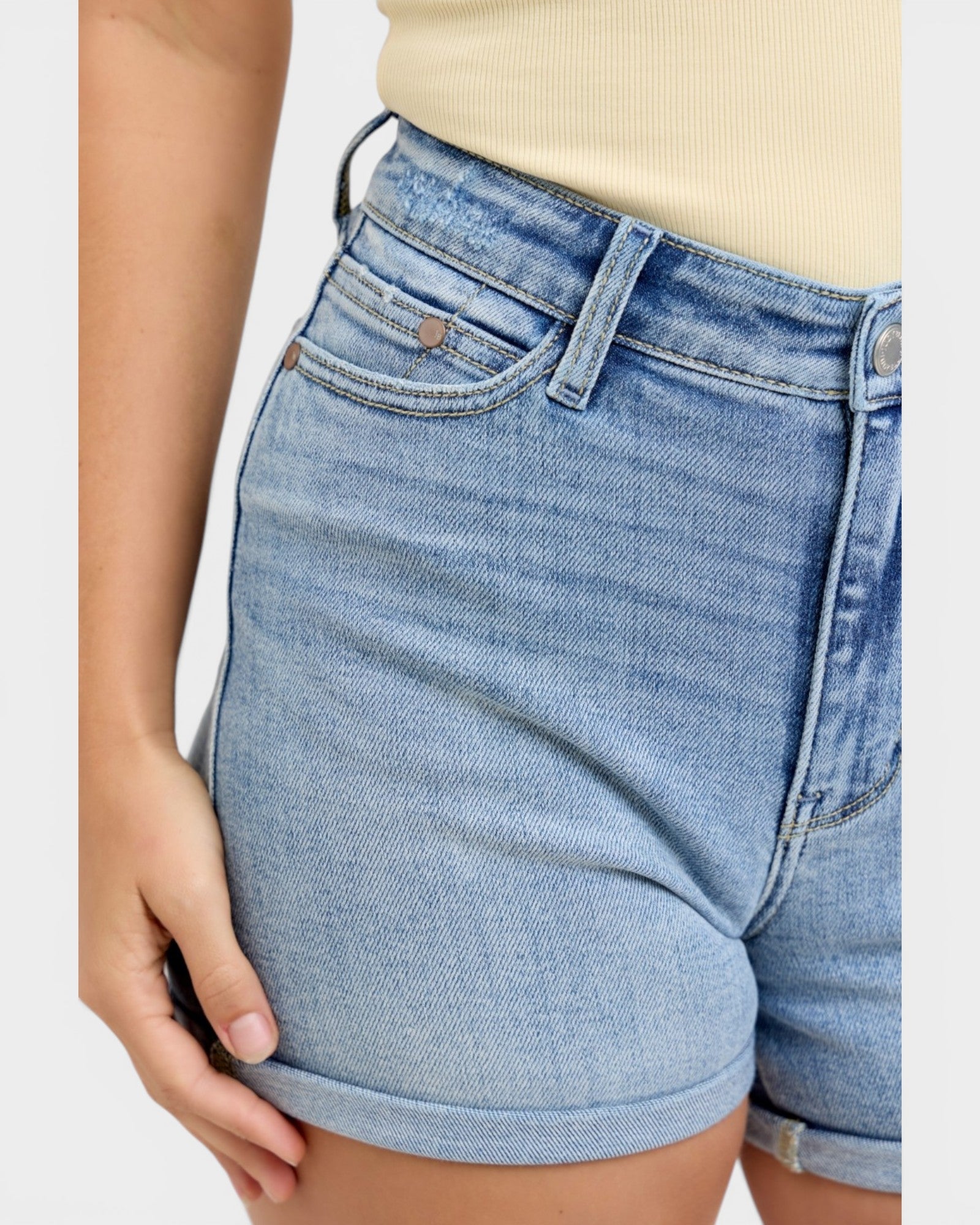 Light blue denim shorts worn by a person on a white background