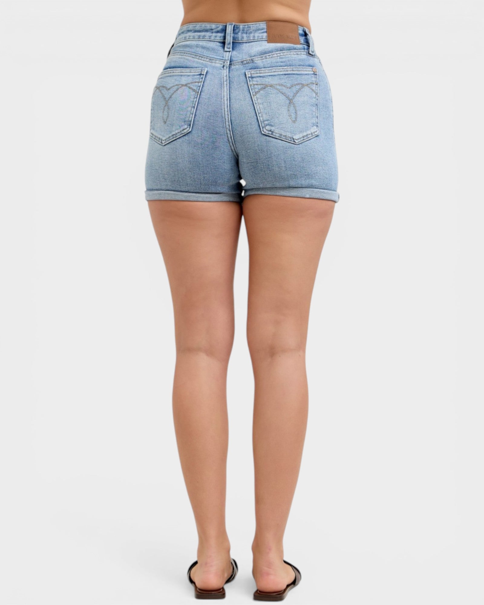 Person wearing light blue denim shorts on a white background