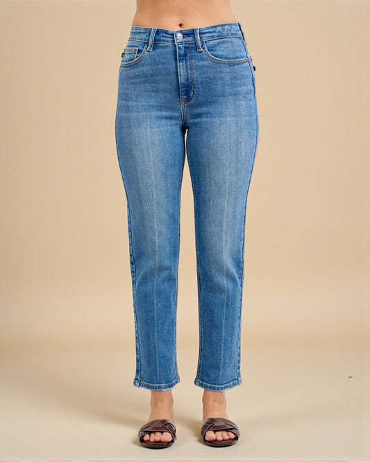 Blue jeans worn by a person on a beige background