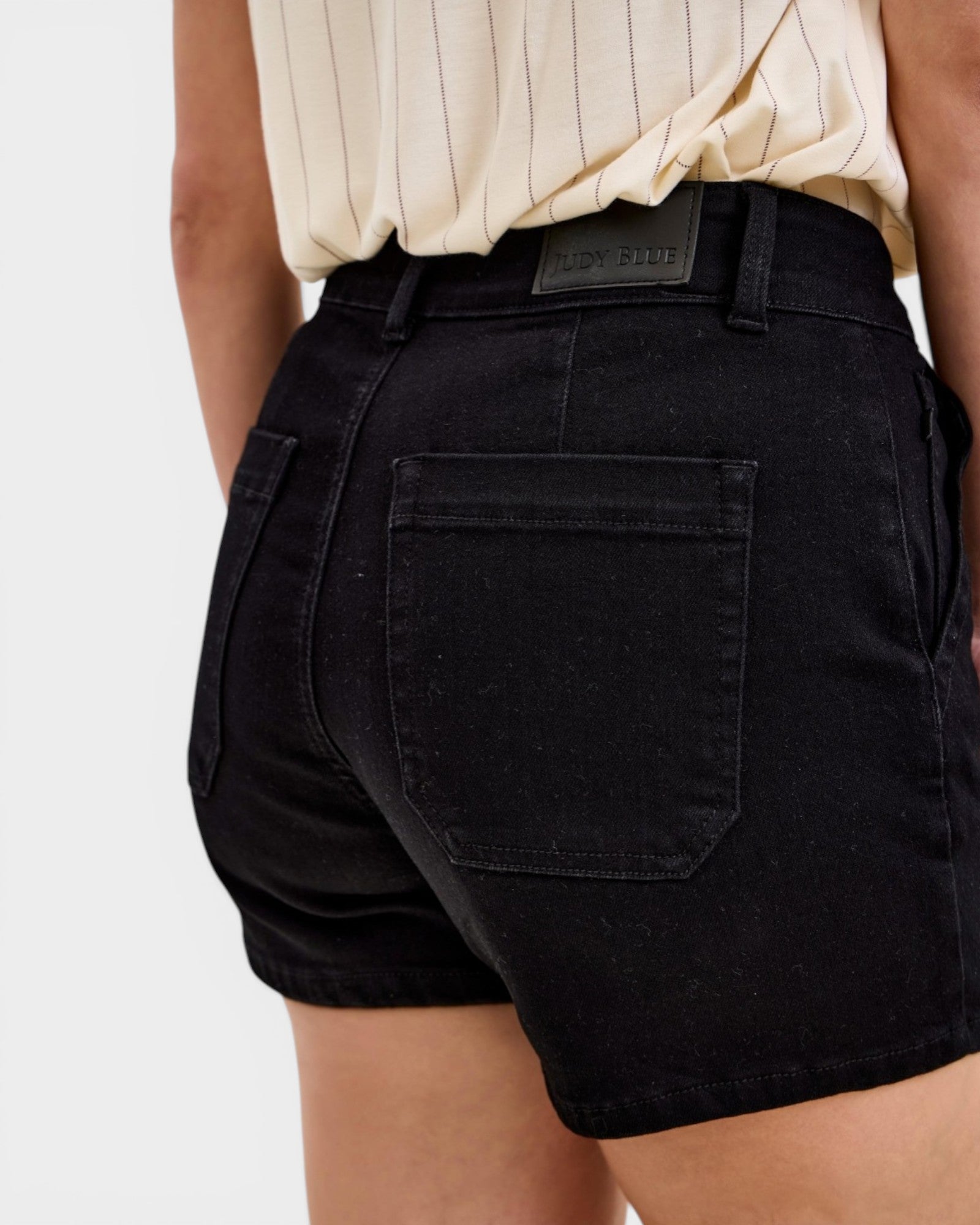 Black shorts worn by a person on a white background