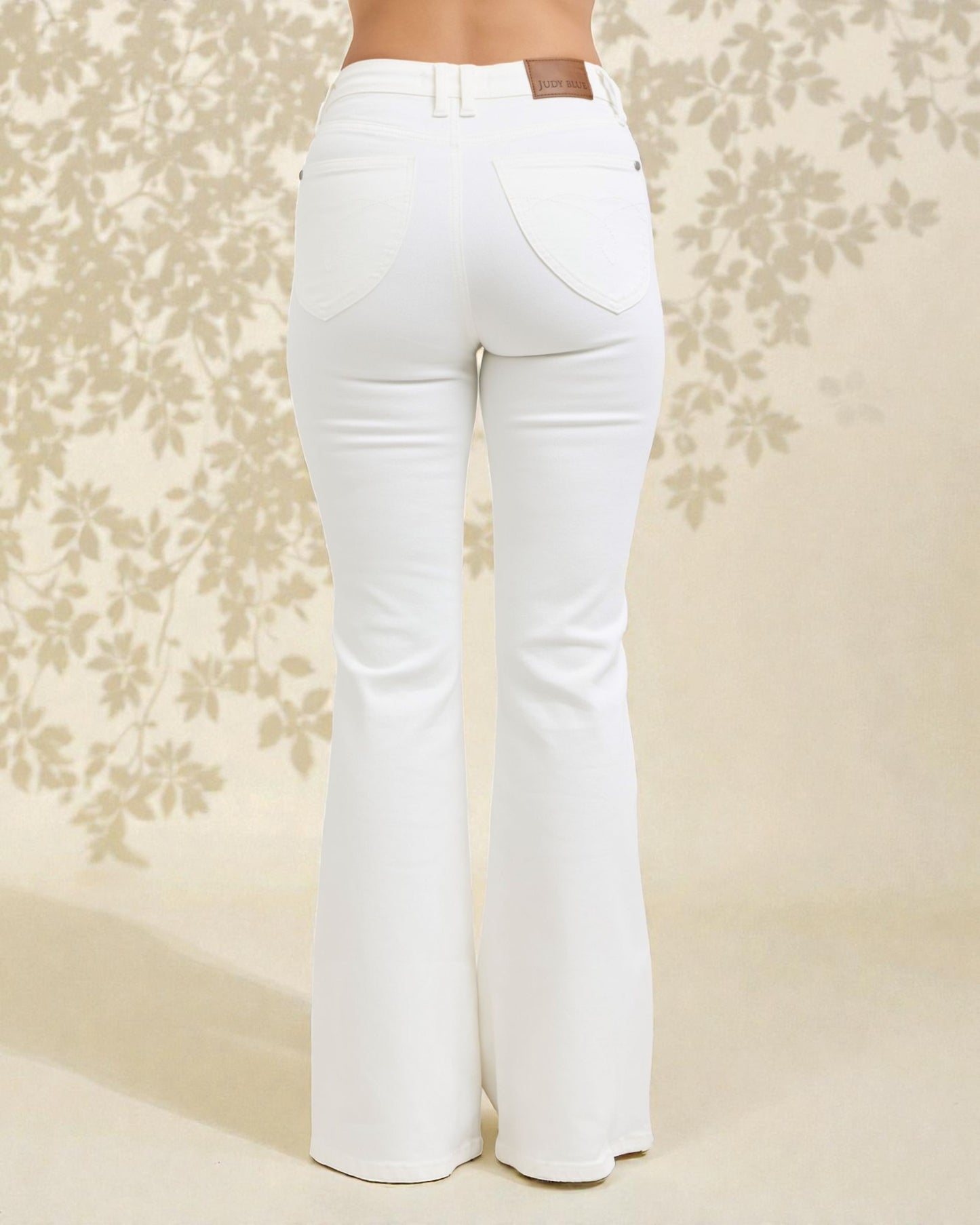 White flared jeans on a floral patterned background
