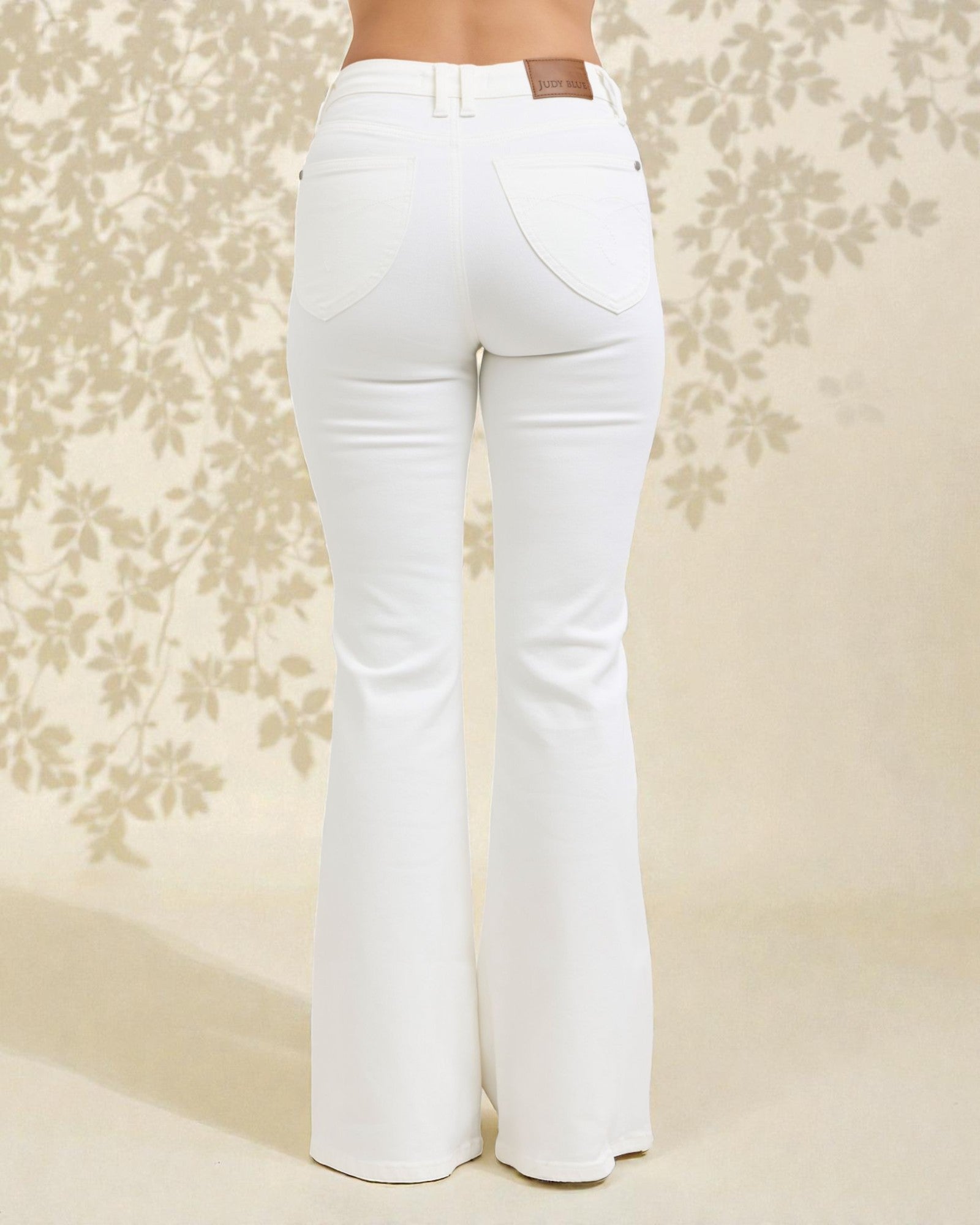 White flared jeans on a floral patterned background